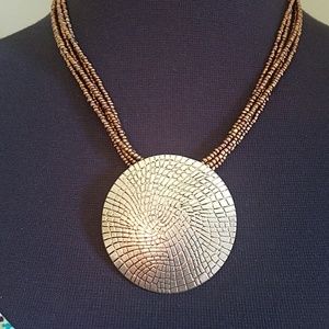 Gold color necklace with metal medallion